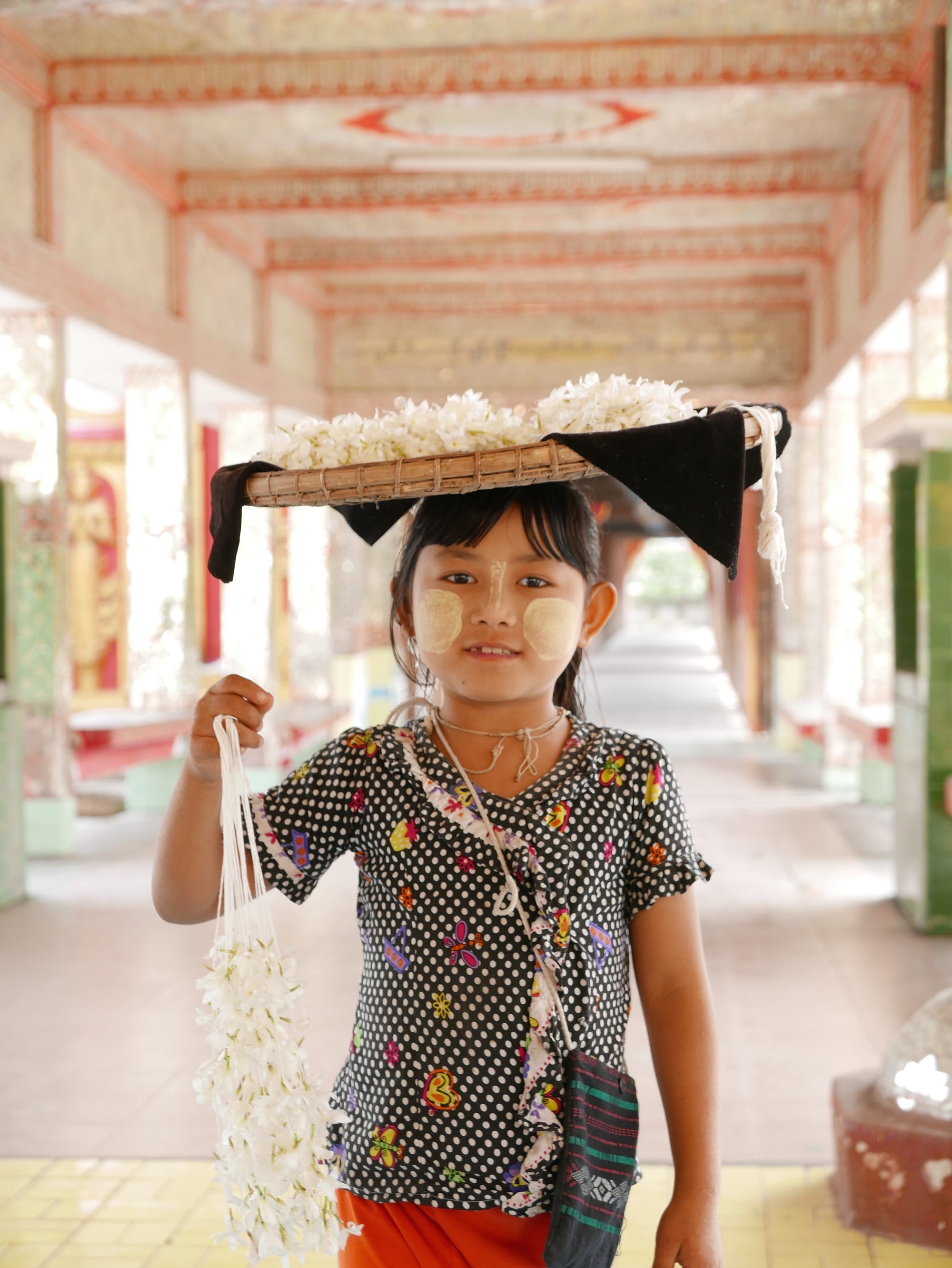 Photo by Author — young flower seller — yellow paste, thanaka — Myanmar (Burma)