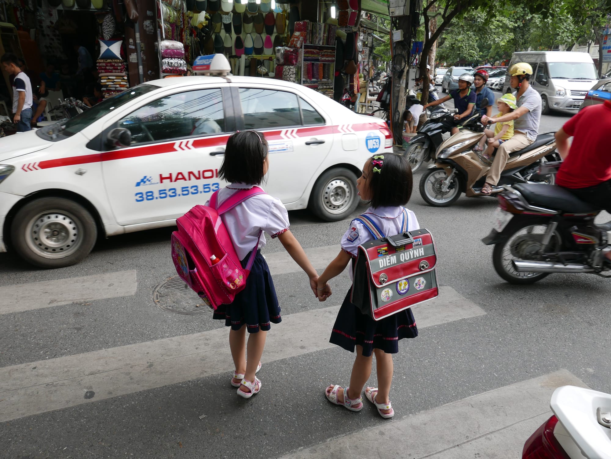 Photo by Author — young school girls crossing the road in Hanoi, Vietnam