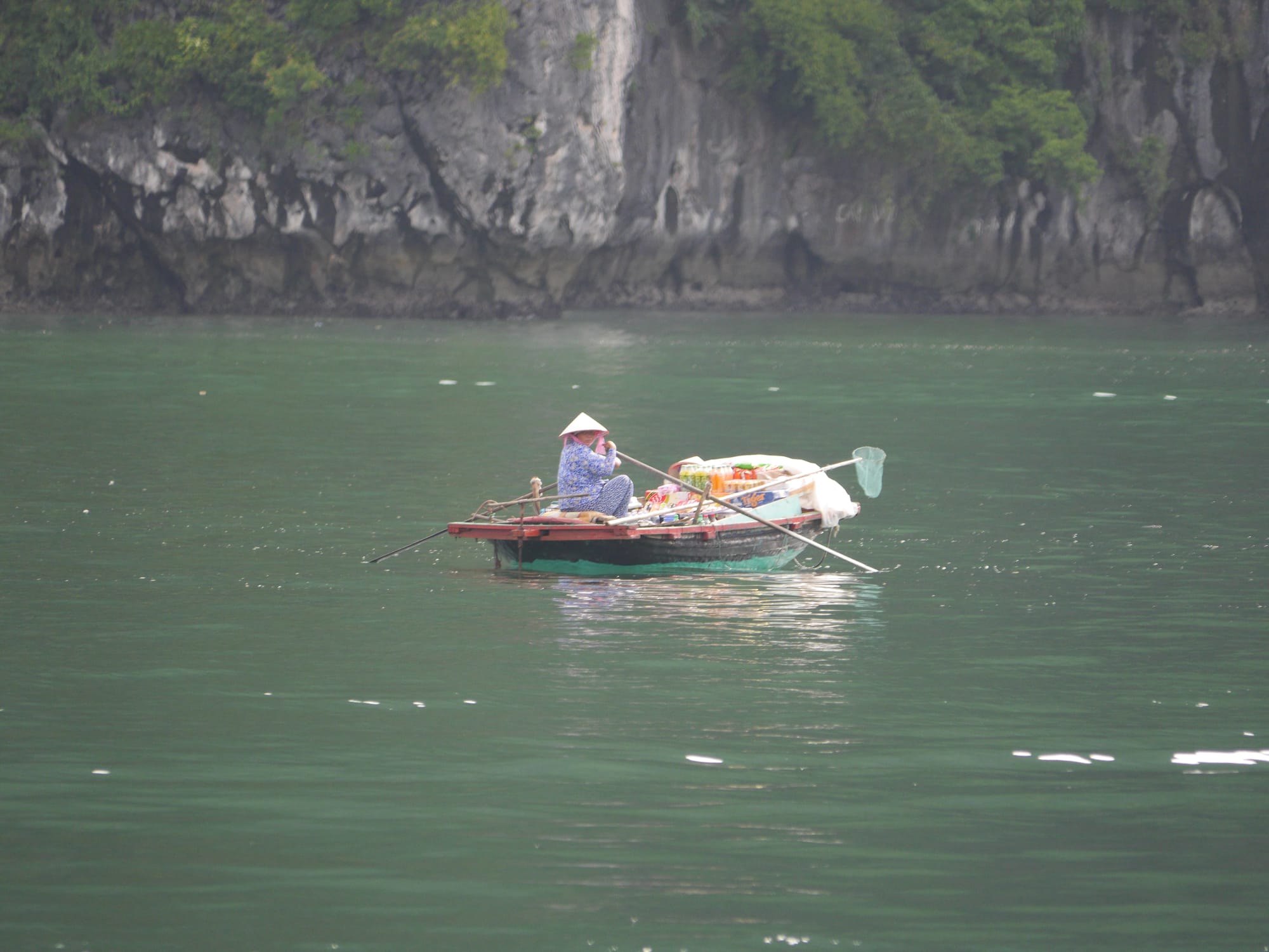 Photo by Author — a local out in a boat — Ha Long Bay, Vietnam