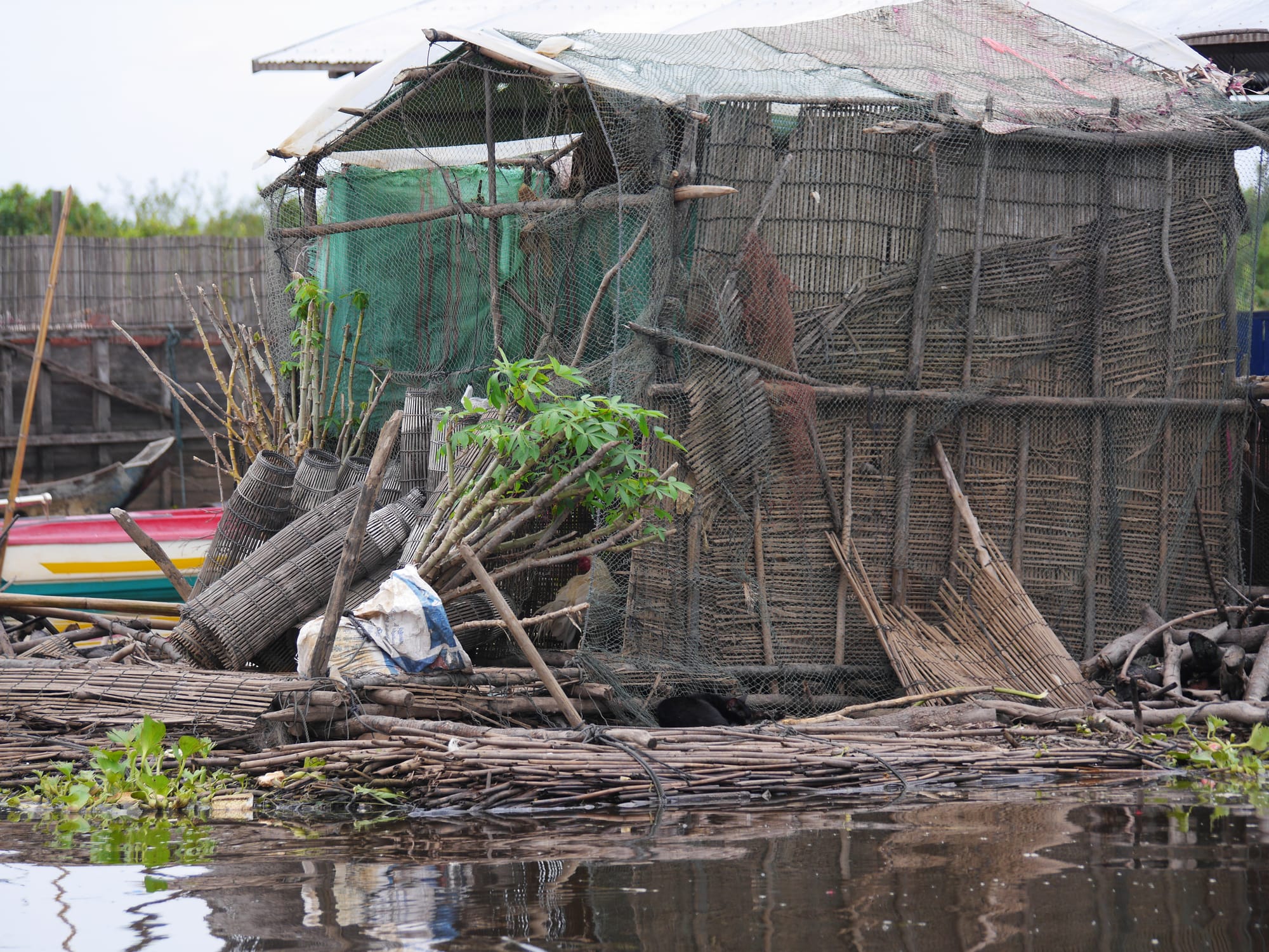 Photo by Author — fish traps and a floating house — Mechrey Floating Village, Siem Reap, Cambodia