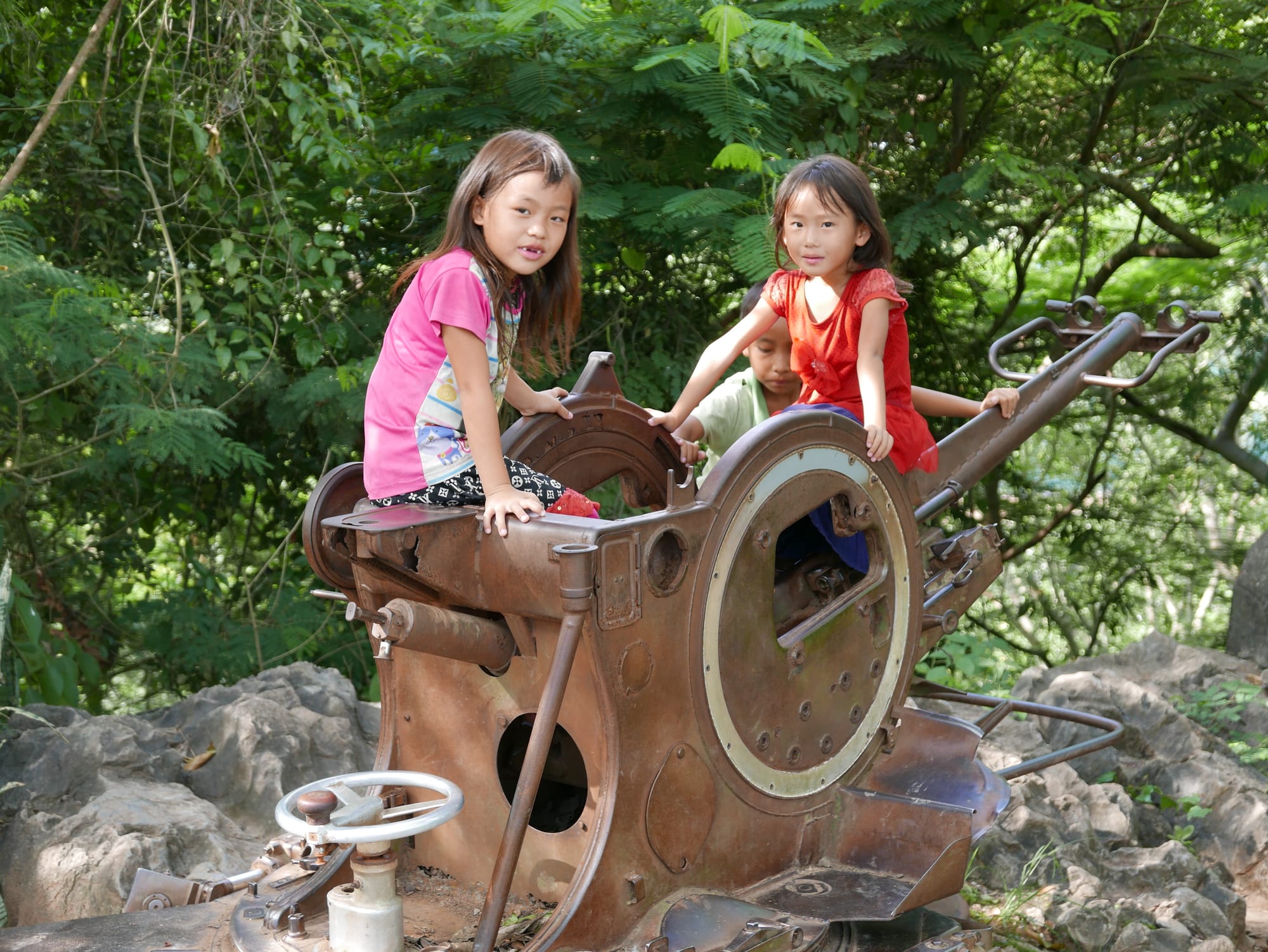 Photo by Author — kids at play on an old anti-aircraft gun — Mount Phousi, Luang Prabang (ຫລວງພະບາງ/ຫຼວງພະບາງ), Laos