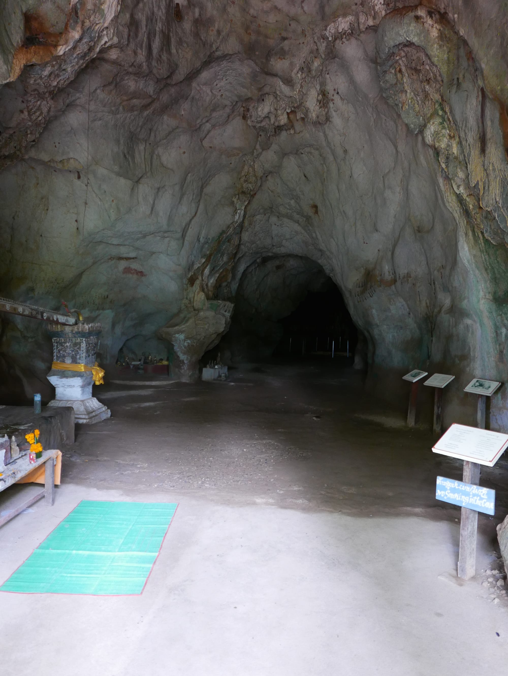 Photo by Author — entering the upper caves — note the carved wooden water channel for washing sculptures of Buddha on the left — Tham Ting (Tam Ting)/Pak Ou (ถ้ำติ่ง) Caves, Laos