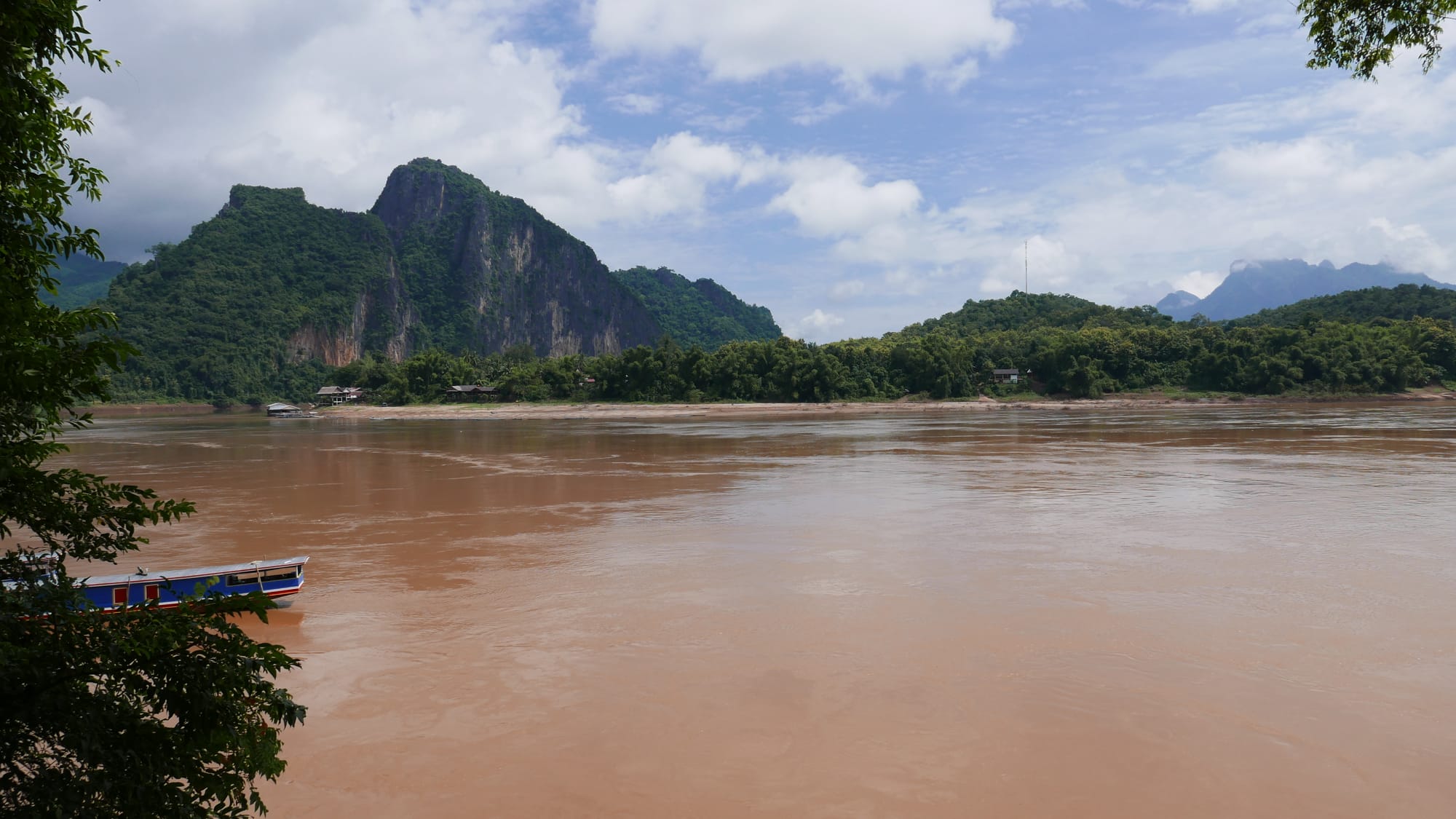 Photo by Author — the Mekong River with the village (Ban Pak Ou) in the distance — Tham Ting (Tam Ting)/Pak Ou (ถ้ำติ่ง) Caves, Laos