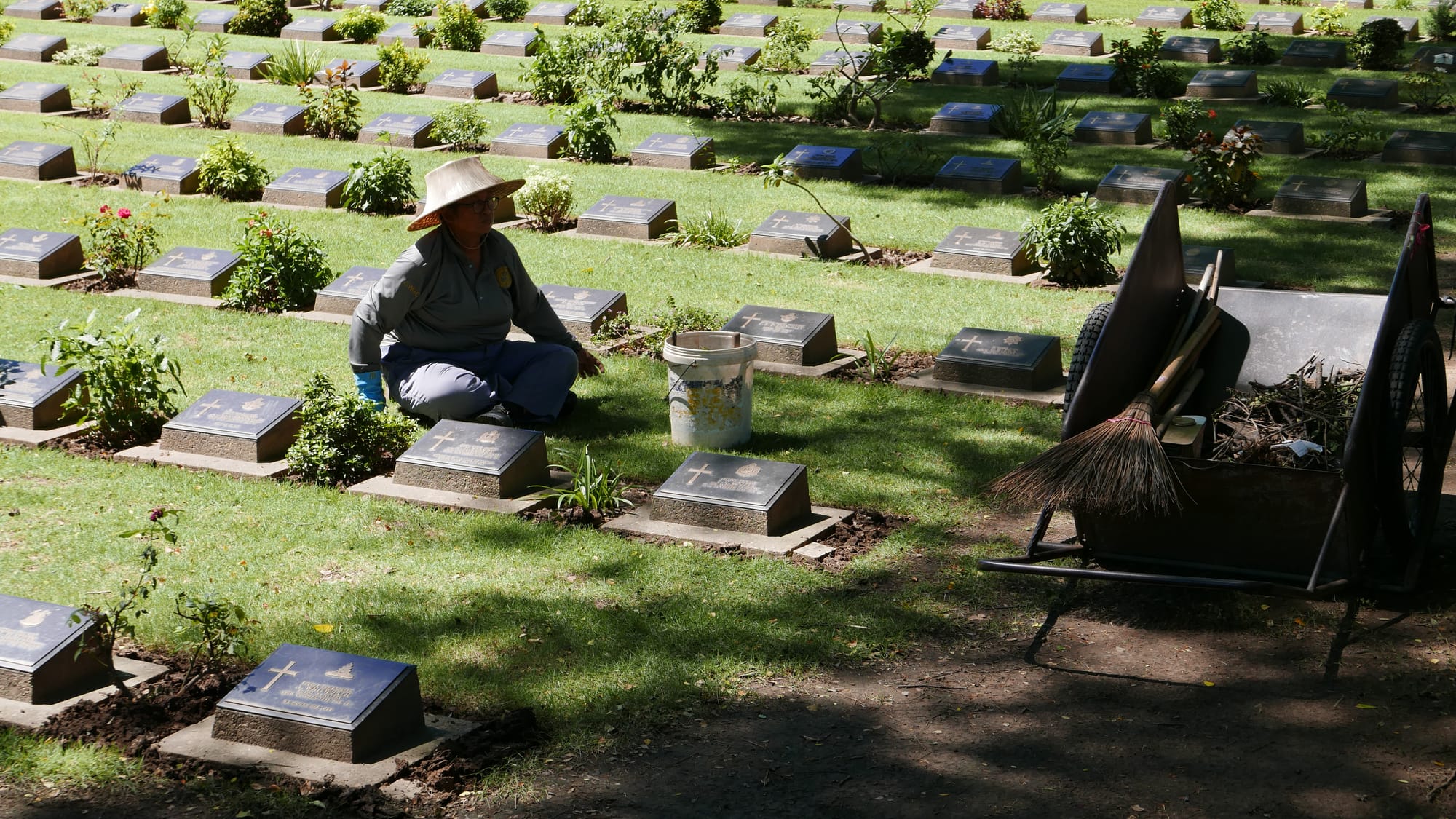 Photo by Author — maintaining the graves — Kanchanaburi Allied War Cemetery (สุสานทหารสัมพันธมิตรกาญจนบุรี), Sangchuto Rd, Mueang Kanchanaburi, Changwat Kanchanaburi 71000, Thailand