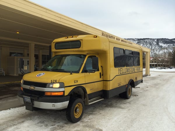 Yellowstone National Park in the Winter - a yellow bus outside the hotel